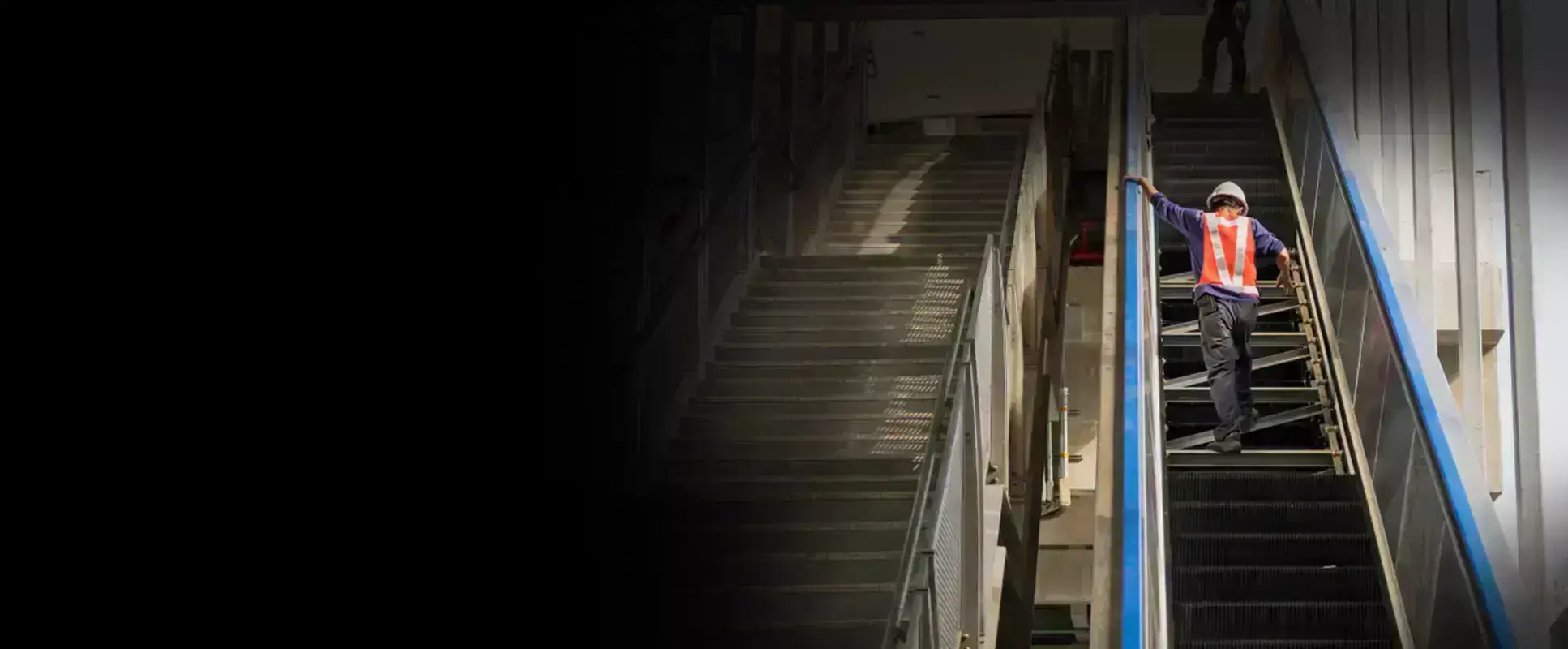 technician walking on escalator checking something